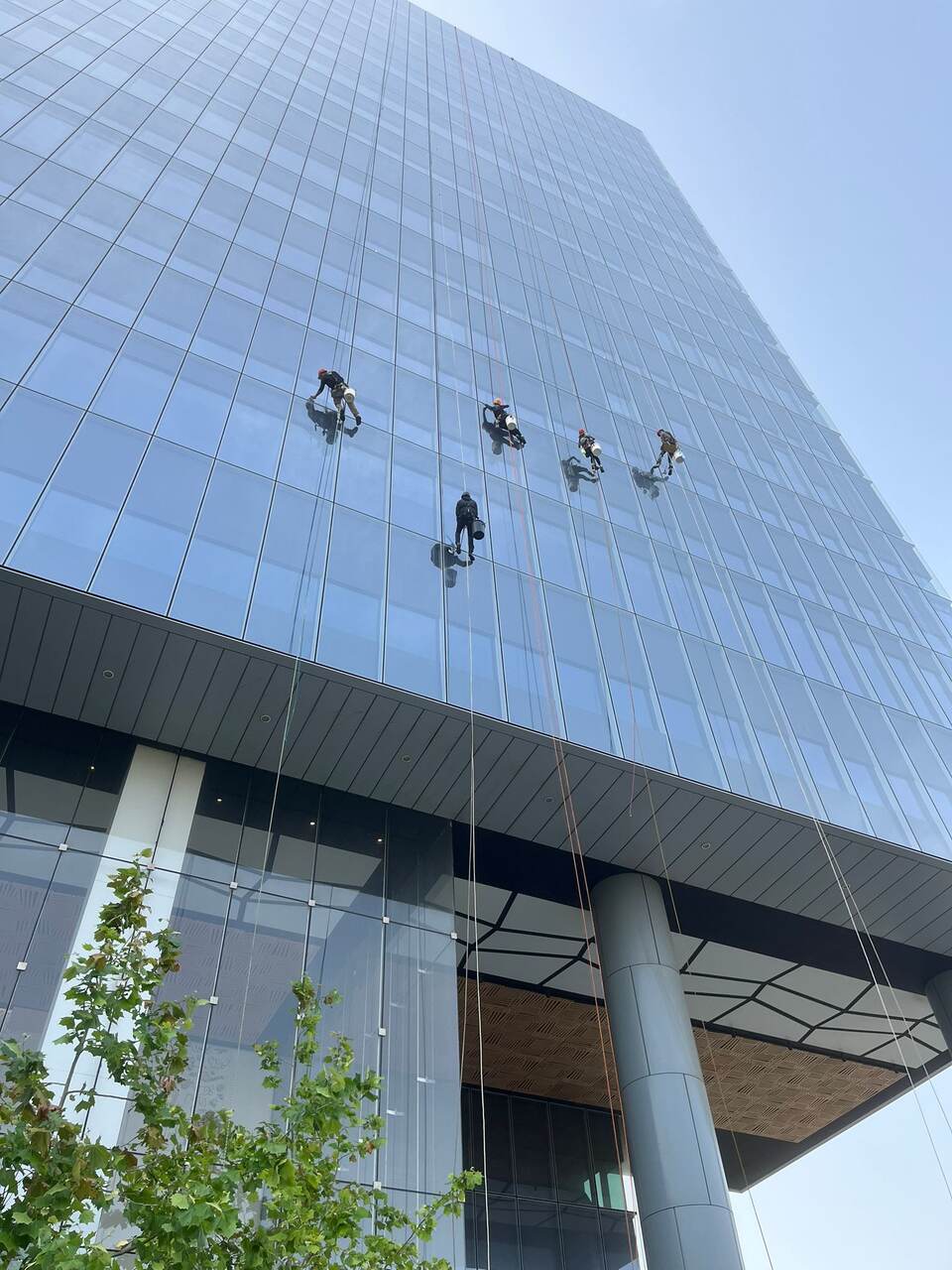 עובד אינסטלטור מתקן צנרת חיצונית בגישת סנפלינג בגובה